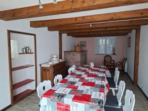 a dining room with a long table and white chairs at La Maison du Cordonnier in Fréland +6 photos