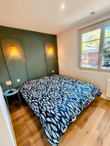 a bedroom with a bed in a room with two windows at Maison centre ville et lac Hossegor in Soorts-Hossegor