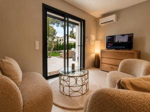 a living room with two chairs and a glass table at La petite maison in Mougins