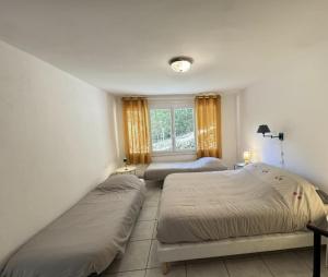 a bedroom with two beds and a window at Logis PONIENTE in Arles-sur-Tech +7 photos