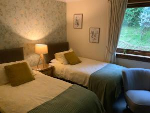 a hotel room with two beds and a window at Cairnryan Bed and Breakfast in Cairnryan