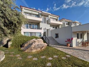 a large white building with a rock in front of it at 7 Grapes in Elevtheraí +24 photos