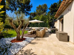 a patio with a tree in the middle of a yard at La petite maison in Mougins