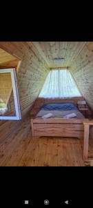 a bed in a wooden room with a window at Cottage Irko in Tvebishi