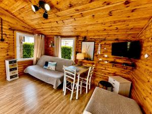 a living room with a couch and a table at Domki Promyk in Mrzeżyno