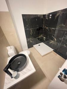 a bathroom with a black toilet and a sink at Aparthotel New Palmarium in Amélie-les-Bains-Palalda +28 photos