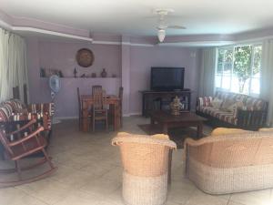 a living room with chairs and a couch and a tv at Flats D'amoras em Conservatória sem café da manhã in Conservatória