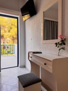 a bathroom with a vanity with a mirror and a window at Vassilis Studios in Poros
