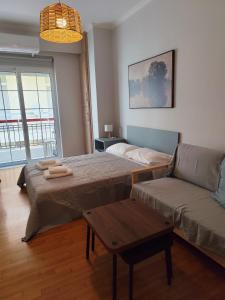 a living room with a bed and a couch at Parastaseis One Bedrooom Flat Georges Square in Patra