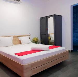 a bedroom with a large bed with a black cabinet at Narjis in Dzaoudzi
