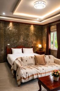 a bedroom with a large bed and a couch at DD HOMESTAy หาดสะพลี in Ban Tha Samet (1)