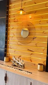 a wooden wall with a mirror and a vase on a shelf at Satya Avenue Dehradun, Near Pearl Paradise IT park Road in Dehradun +30 photos