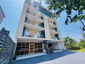 a tall white building with windows and balconies at Satya Avenue Dehradun, Near Pearl Paradise IT park Road in Dehradun
