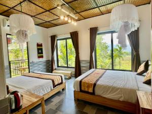 two beds in a room with large windows at Puluong Aroma in Lũng Tiềm
