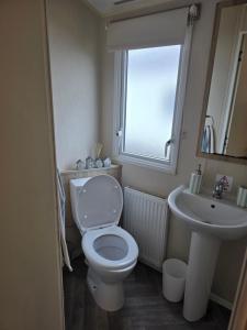 a bathroom with a toilet and a sink at Beachside caravan retreat - at New Beach, Dymchurch in Dymchurch