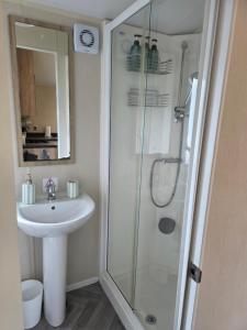 a bathroom with a sink and a glass shower at Beachside caravan retreat - at New Beach, Dymchurch in Dymchurch