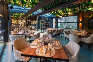 a dining room with tables and chairs and plants at Хотел Дом на Алпиниста in Vratsa