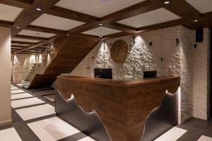 a lobby with a wooden reception desk and chairs at Хотел Дом на Алпиниста in Vratsa