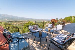 a group of chairs and tables on a balcony with a view at U Scogliu Escale De Rêve in Poggio-dʼOletta