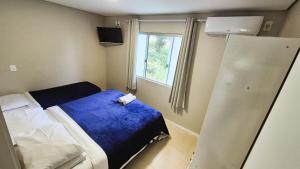 a small room with a bed and a window at Ipê Eco Village, Apartamentos perto do Beto Carrero in Penha