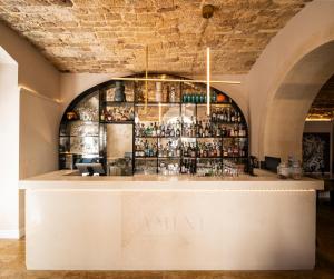 a bar at a restaurant with a brick wall at Palazzo Artemide - VRetreats, an SLH Hotel in Syracuse +17 photos