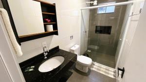 a bathroom with a sink and a toilet and a shower at Ipê Eco Village, Apartamentos perto do Beto Carrero in Penha