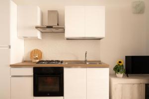 a kitchen with white cabinets and a sink and a stove at Sarmalia 32 a pochi passi dal centro di Nardò in Nardò