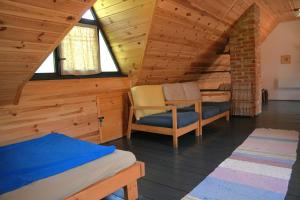 a bedroom with a bed and a chair in a attic at Bed&More Almáspuszta in Jestice
