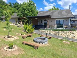 a yard with benches and a fire pit in front of a house at Sümeg Horizon in Sümeg