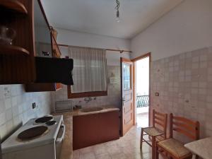 a kitchen with a stove and a sink in it at Μπαλκόνι Στο Γαλάζιο in Agios Georgios