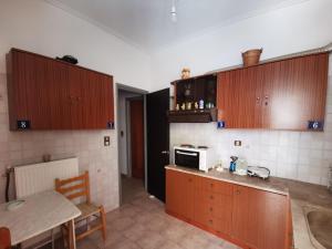 a kitchen with wooden cabinets and a table and a microwave at Μπαλκόνι Στο Γαλάζιο in Agios Georgios +68 photos