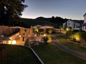 a backyard with tables and umbrellas at night at Weinburg -Das Ferienhaus in Cochem