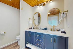 a bathroom with a blue vanity and a mirror at Hill House in Belfair