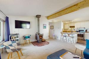 a living room with a fireplace and a kitchen at Hill House in Belfair