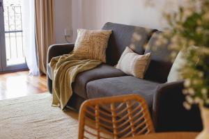 a living room with a blue couch with pillows at Bravissimo Nou del Teatre, with panoramic views in Girona