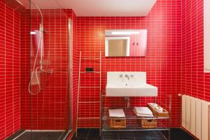 a red tiled bathroom with a sink and a shower at Bravissimo Nou del Teatre, with panoramic views in Girona +27 photos