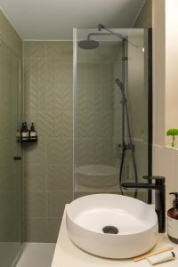 a bathroom with a shower with a white sink at Bob W Munich City West in Munich +26 photos