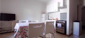 a kitchen with a table with chairs and a stove at Alloggio Maia 2 in Biella +14 photos