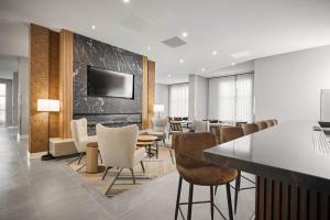 a conference room with a bar and chairs and a tv at Four Points by Sheraton Oakville in Oakville +21 photos