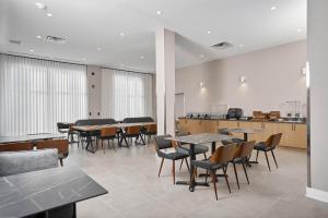 a dining room with tables and chairs and a kitchen at Four Points by Sheraton Oakville in Oakville