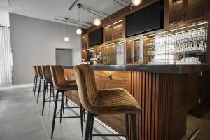 a bar with a row of bar stools in a room at Four Points by Sheraton Oakville in Oakville