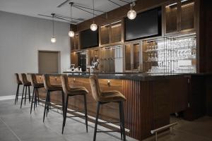 a bar with a bunch of stools in a room at Four Points by Sheraton Oakville in Oakville