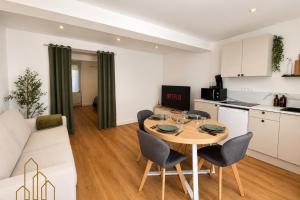 a kitchen and living room with a table and chairs at L'Échappée du Canal in Roanne