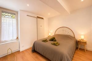 a bedroom with a large bed and a window at L'Échappée du Canal in Roanne