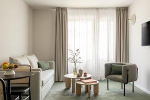 a living room with a couch and a table at Bob W Munich City West in Munich