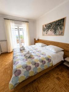 a bedroom with a large bed with a colorful blanket at Apartment Vrenjak in Portorož