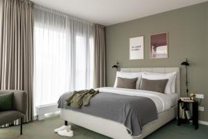 a bedroom with a large bed and a chair at Bob W Munich City West in Munich