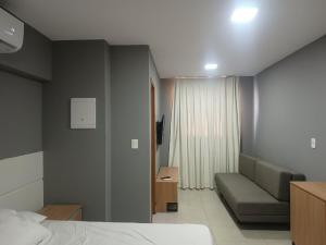 a hotel room with a bed and a couch at Vila Atlântida BEACH FLAT 311B in Luis Correia