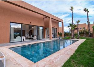 a swimming pool in front of a house at The Oasis Marakech in Marrakesh