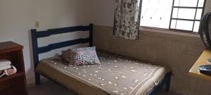 a small bed with a pillow on it in a room at Hotel Montreal in Abadiânia